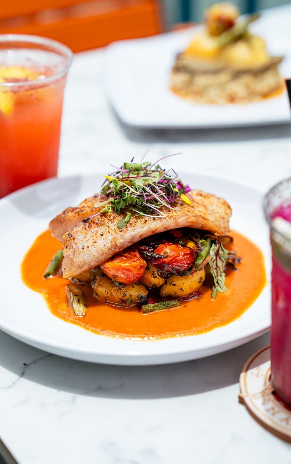 Mahi-mahi with sauce, framed by frozen drinks